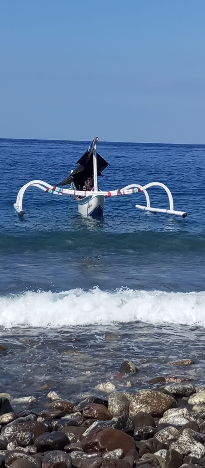 Jukung boat departing from the shore in Amed