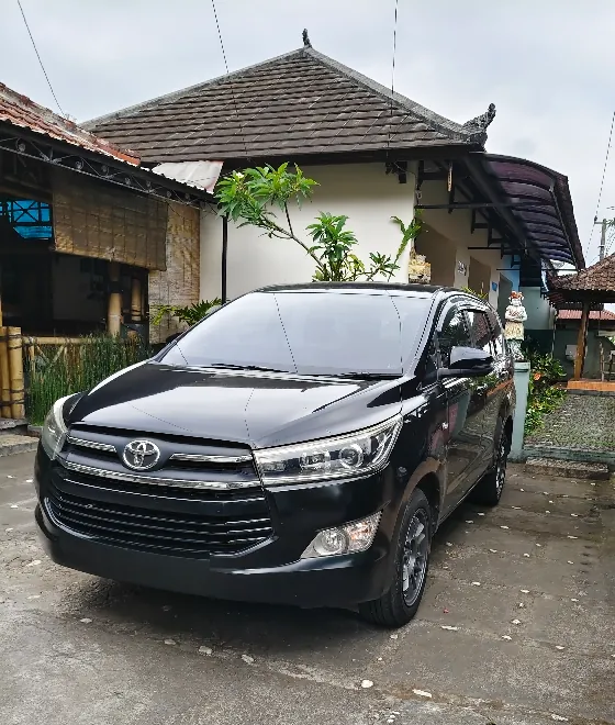 Putu's Toyota Innova Reborn parked at his family home in Amed